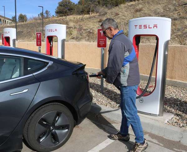 Tesla owner plugging in a Tesla vehicle to charge